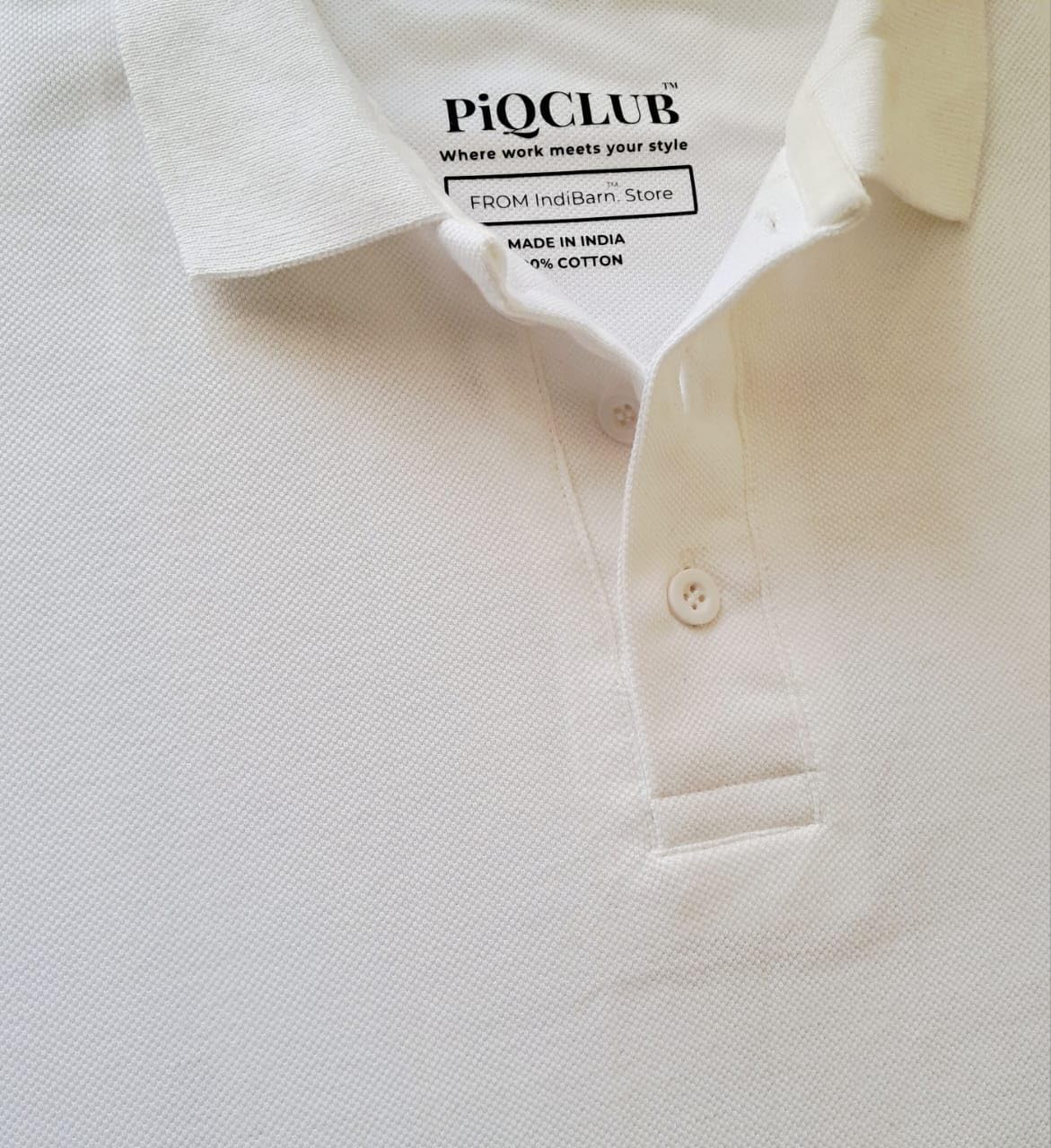 Close-up of a white polo shirt with Piqclub label